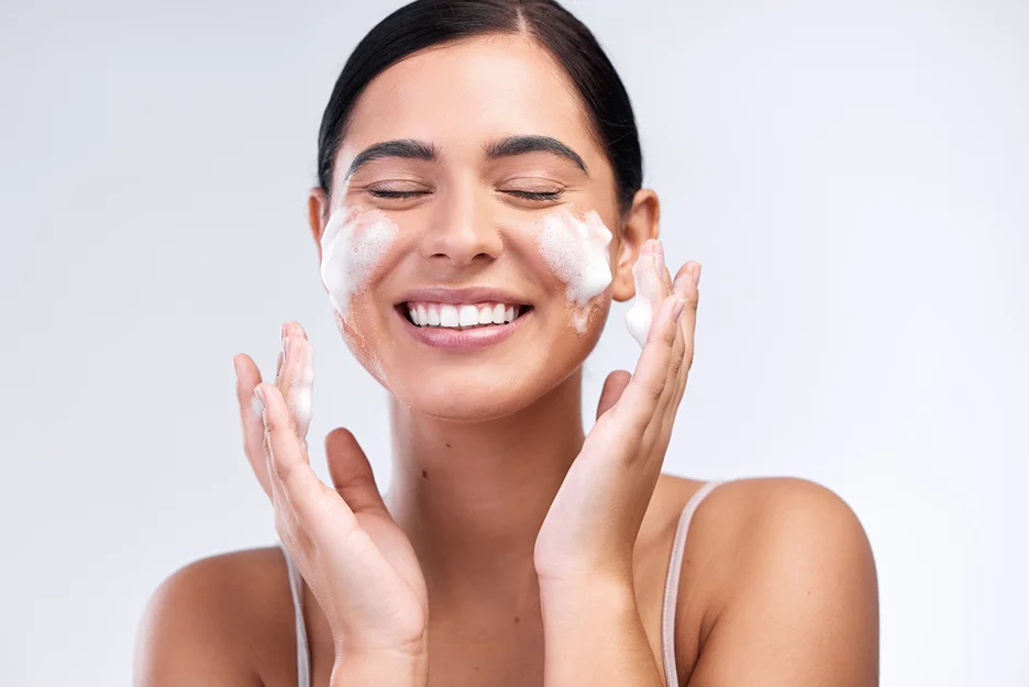 a woman washes her face with a facial cleanser after chemical peel procedure